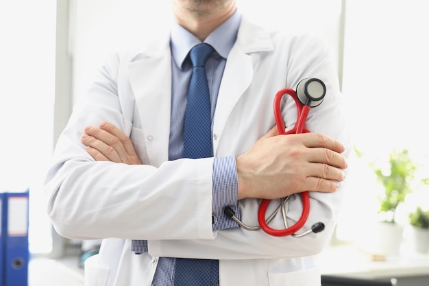 Doctor masculino en una bata blanca con un estetoscopio en sus manos