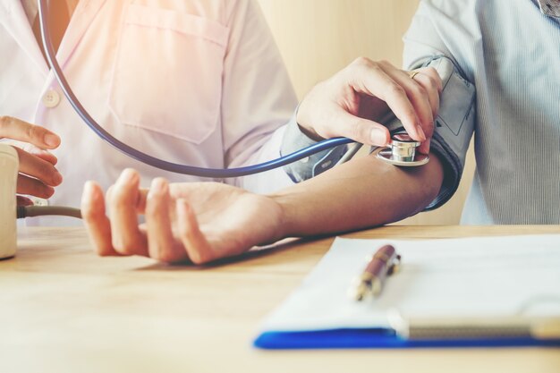 Doctor Measuring arterial blood pressure mujer paciente