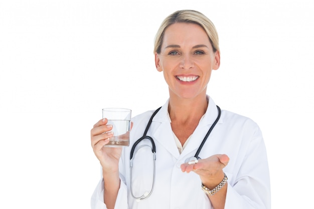 Doctor con medicamentos y un vaso de agua en sus manos
