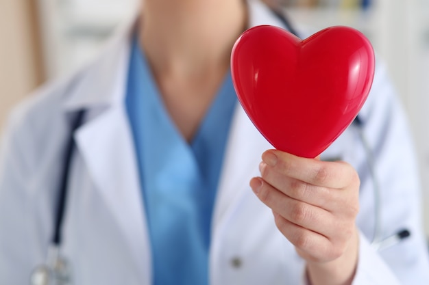 Doctor en medicina femenina sosteniendo corazón rojo closeup