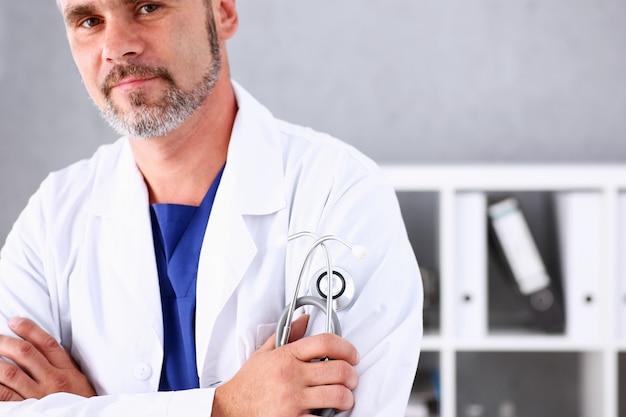 Foto doctor en medicina masculina brazos cruzados sobre su pecho en la oficina