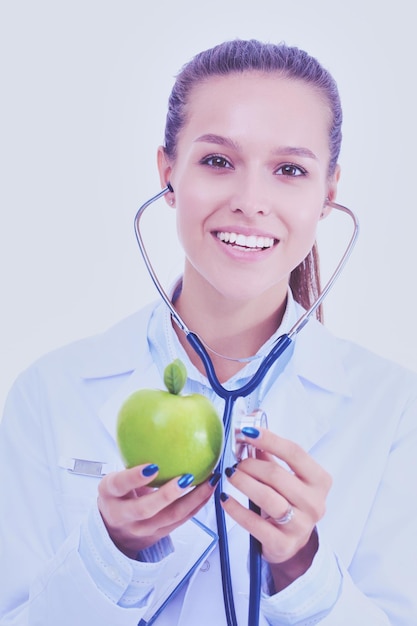 Doctor en medicina mujer examinando manzana con estetoscopio