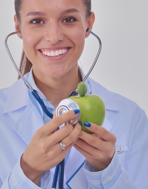 Doctor en medicina mujer examinando manzana con estetoscopio