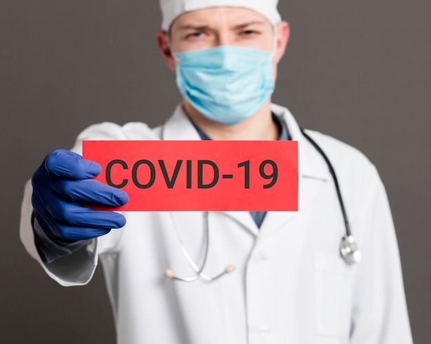 Foto doctor en medicina con tarjeta covid-19