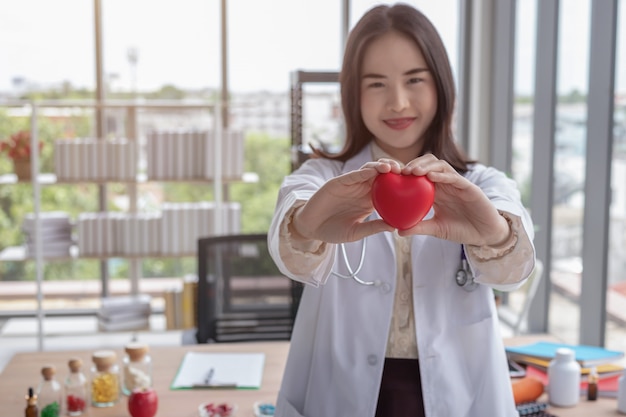 El doctor muestra un corazón rojo en la oficina