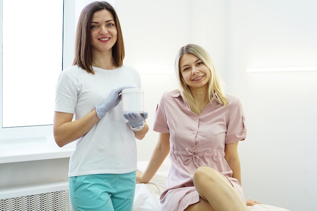 El doctor muestra el remedio del paciente en el salón de belleza. Cosmetología que el médico aconseja al paciente.