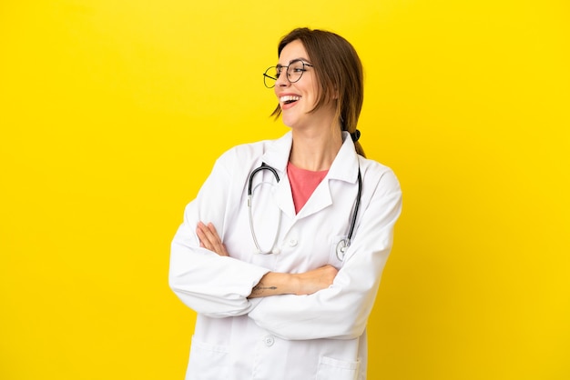 Doctor mujer aislada sobre fondo amarillo feliz y sonriente