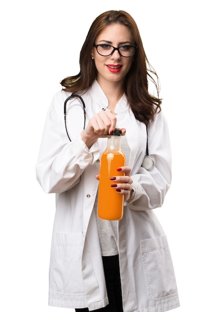 Doctor mujer sosteniendo un jugo de naranja