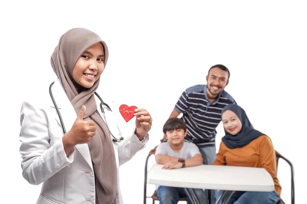 Doctor musulmán sonriendo con la familia en el fondo