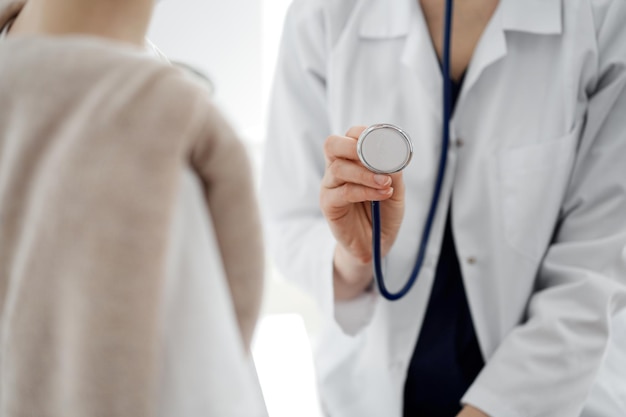 Doctor y un niño paciente. El médico sostiene un estetoscopio y está listo para examinar al niño. Concepto de salud perfecto en medicina.