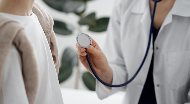 Doctor y un niño paciente. El médico sostiene un estetoscopio y está listo para examinar al niño. Concepto de salud perfecto en medicina.