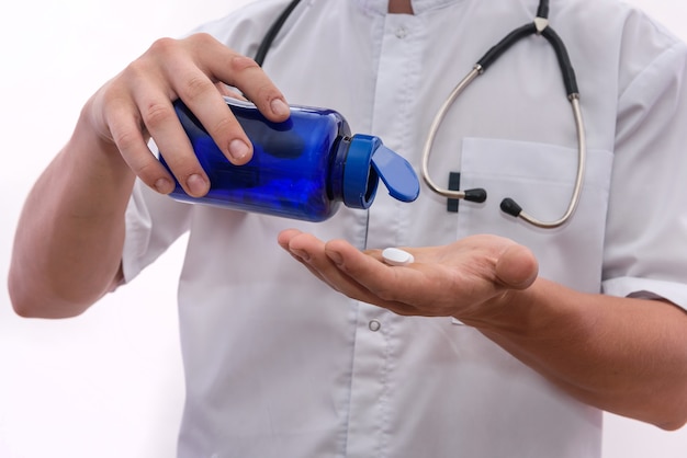 Doctor ofreciendo pastillas blancas. Concepto de medicación y farmacia