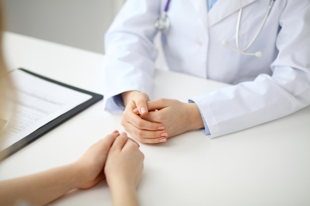 El doctor y el paciente están discutiendo algo, apenas las manos en la tabla.