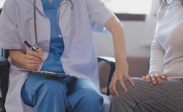 Doctor y paciente hablando mientras están sentados en el escritorio en la oficina del hospital primer plano de manos humanas Medicina y concepto de atención médica