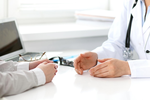 Doctor y paciente sentados en el escritorio. Concepto de medicina y atención de la salud.