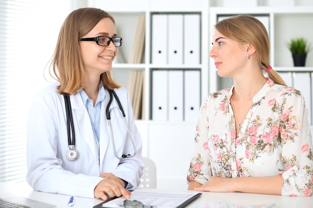 Doctor y paciente sentados en el escritorio.