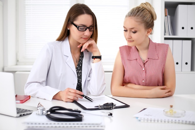 Doctor y paciente sentados en el escritorio.