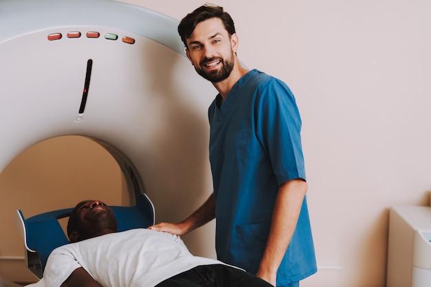 Foto doctor positivo launching ct scanner afro patient.