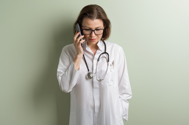 Doctor positivo mujer hablando teléfono móvil