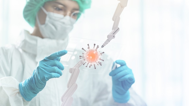 Doctor en ppe suite mano mantenga pantalla de tableta transparente que muestra la célula del virus corona con brazo robótico.