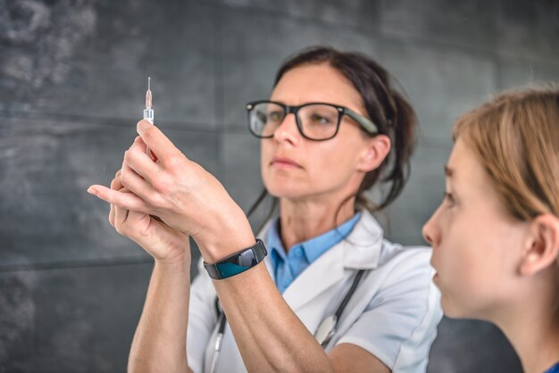 Doctor preparando una vacuna para inyectar en un paciente