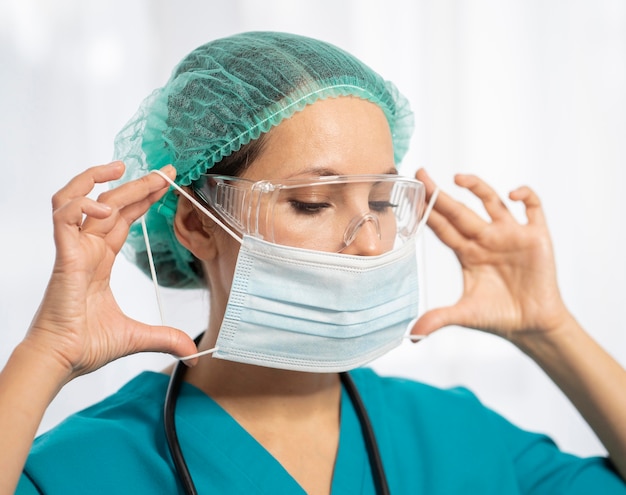 Foto doctor de primer plano poniéndose mascarilla