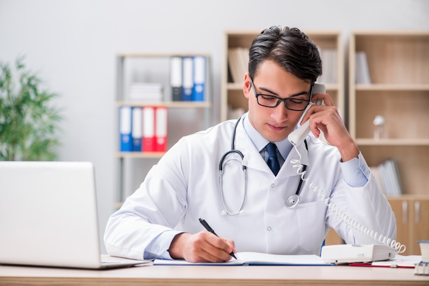 Doctor que consulta al paciente por teléfono.