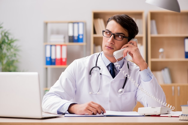 Doctor que consulta al paciente por teléfono.