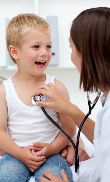 Un doctor que controla el pulso en un niño sonriente