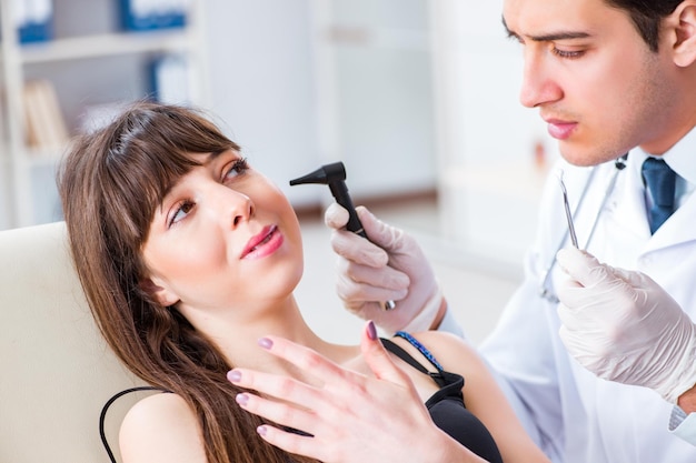 Foto doctor revisando el oído de los pacientes durante el examen médico