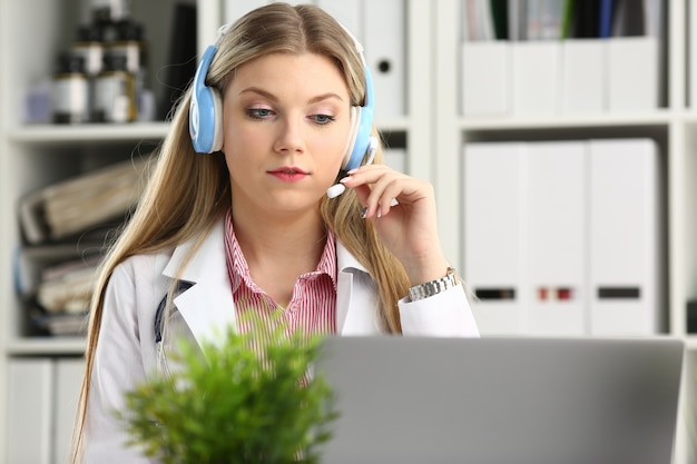 Doctor rubio hablando con el paciente con auriculares inalámbricos