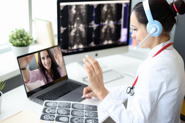 Doctor sentado en consultorio médico en auriculares con micrófono