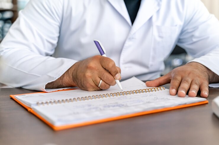 Foto doctor sentado en el escritorio. diagnóstico de escritura de especialista médico. recetar medicamentos. foto recortada.