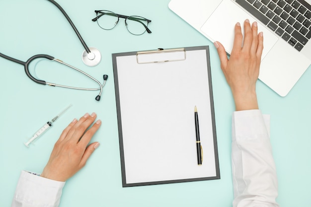 Foto doctor sentado en el escritorio de oficina azul y trabajando