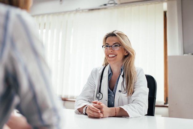 Doctor de sexo femenino sonriente con un paciente en la oficina.