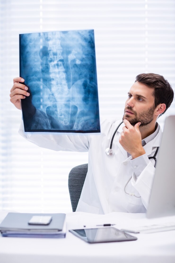 Foto doctor de sexo masculino que examina la radiografía