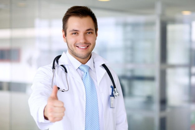 Doctor de sexo masculino sonriente con el pulgar para arriba