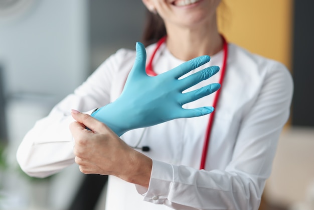 Foto doctor sonriente pone guante en su mano