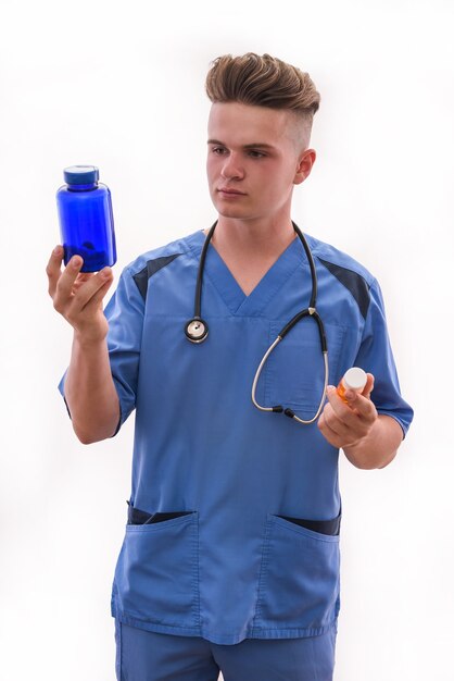 Doctor sosteniendo la botella con pastillas aislado sobre fondo blanco.