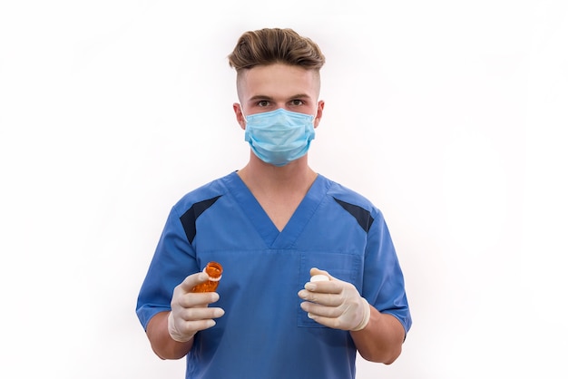 Doctor sosteniendo la botella con pastillas aislado sobre fondo blanco.