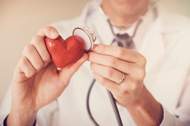 Doctor sosteniendo corazón rojo, concepto de seguro de salud del corazón