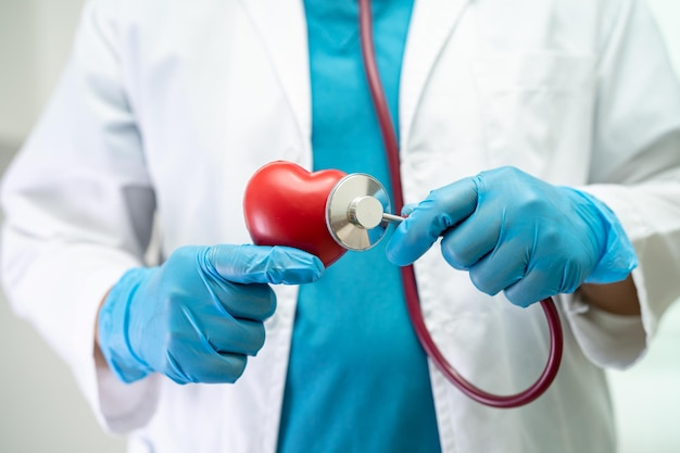 Doctor sosteniendo un corazón rojo en la sala del hospital concepto médico fuerte y saludable