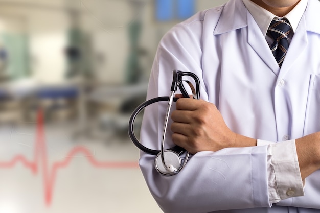 Doctor sosteniendo un estetoscopio con uniforme médico en el hospital