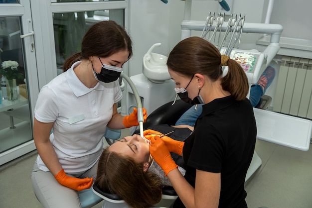 Doctor sosteniendo instrumentos dentales cerca de la boca del paciente para examinarlos. concepto de salud