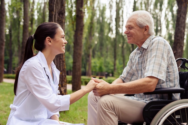 Foto doctor sosteniendo la mano de un anciano sonriente