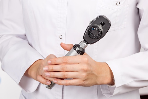 Doctor sosteniendo en la mano funduscopio oftalmoscopio