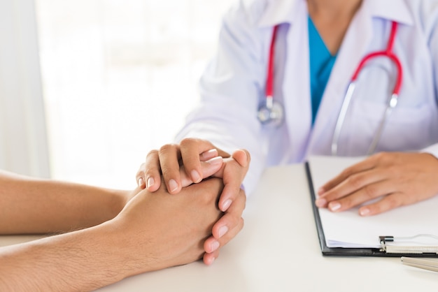 Foto doctor sosteniendo la mano del paciente. concepto de medicina y salud.