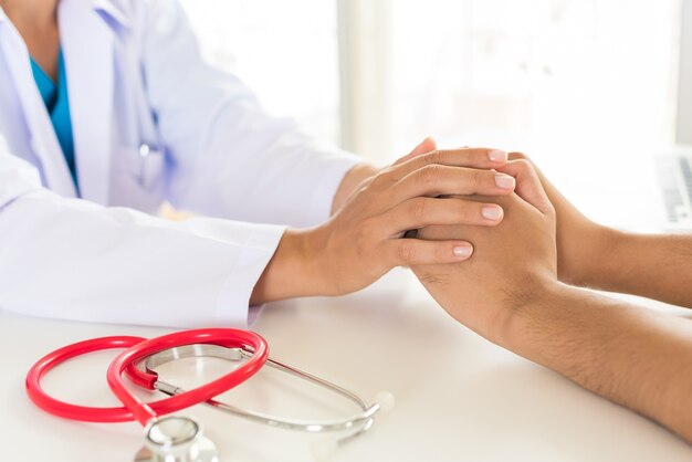 Foto doctor sosteniendo la mano del paciente. concepto de medicina y salud.