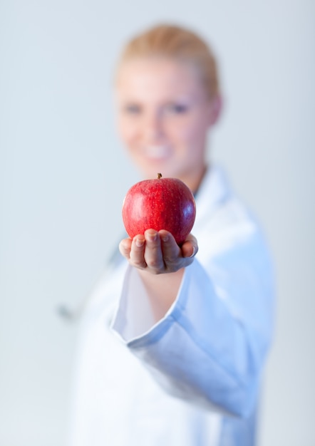 Doctor sosteniendo una manzana con enfoque en la manzana