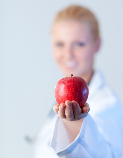 Doctor sosteniendo una manzana con enfoque en la manzana